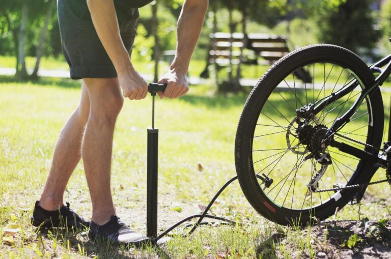 Mand inspicerer sin cykel for at holde den ved lige.